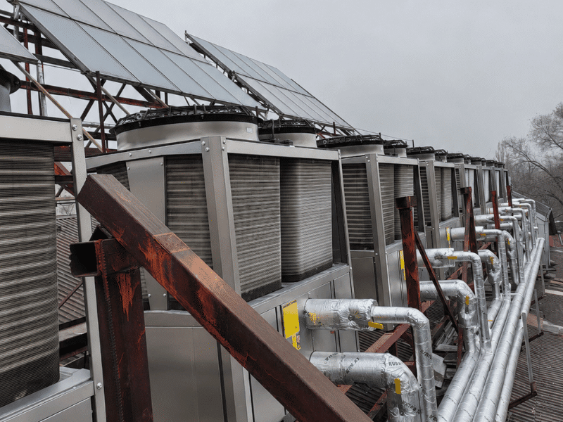 AirProz solar air conditioner heat pump system integrated with rooftop PV panels at an industrial park in Lyon, France, delivering zero-carbon commercial space heating