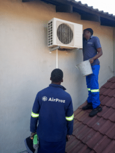 Airproz HVAC technicians installing a split air conditioner outdoor unit