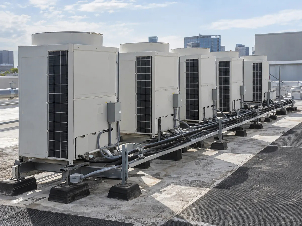 Bank of generic VRF outdoor units on a commercial rooftop with service clearances and piping.