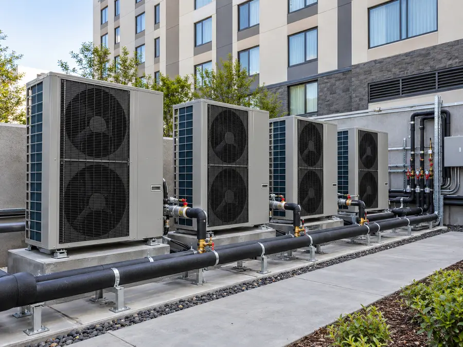 Illustrative scene: outdoor heat-pump units and water-system equipment at a building